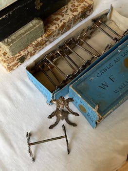 Old metal doorknobs displayed in vintage, decorative boxes on a table.