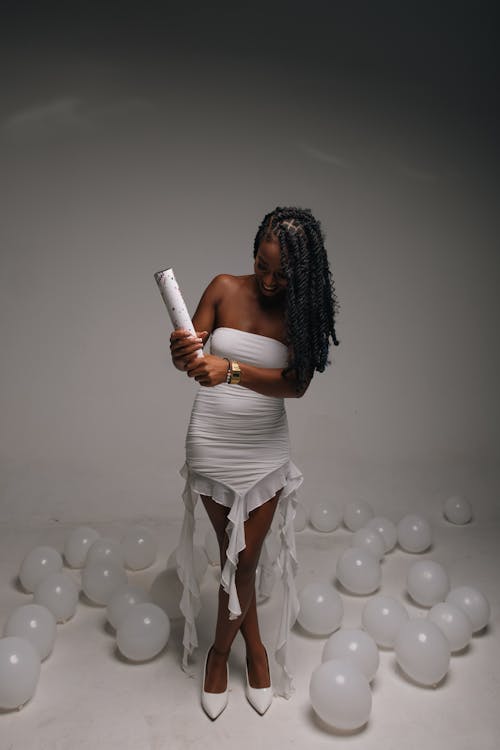 Woman in White Dress Standing among Balloons