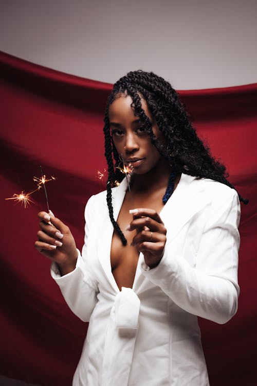 Woman in White Suit Standing with Sparklers