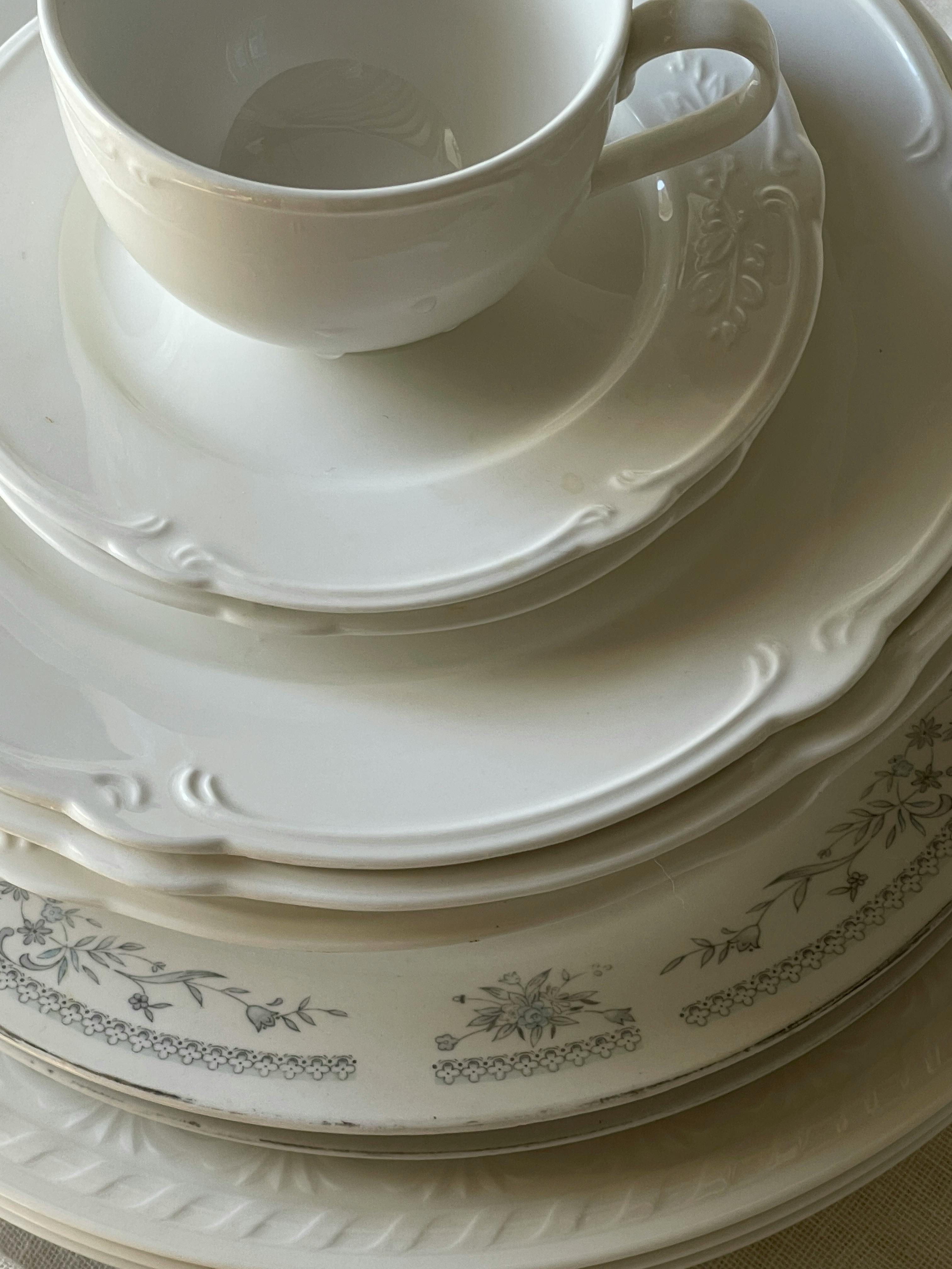 A close-up of elegant white porcelain tableware arranged in a stack, showcasing intricate design.