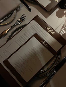 A sophisticated dining setup featuring menus and cutlery at a high-end restaurant.