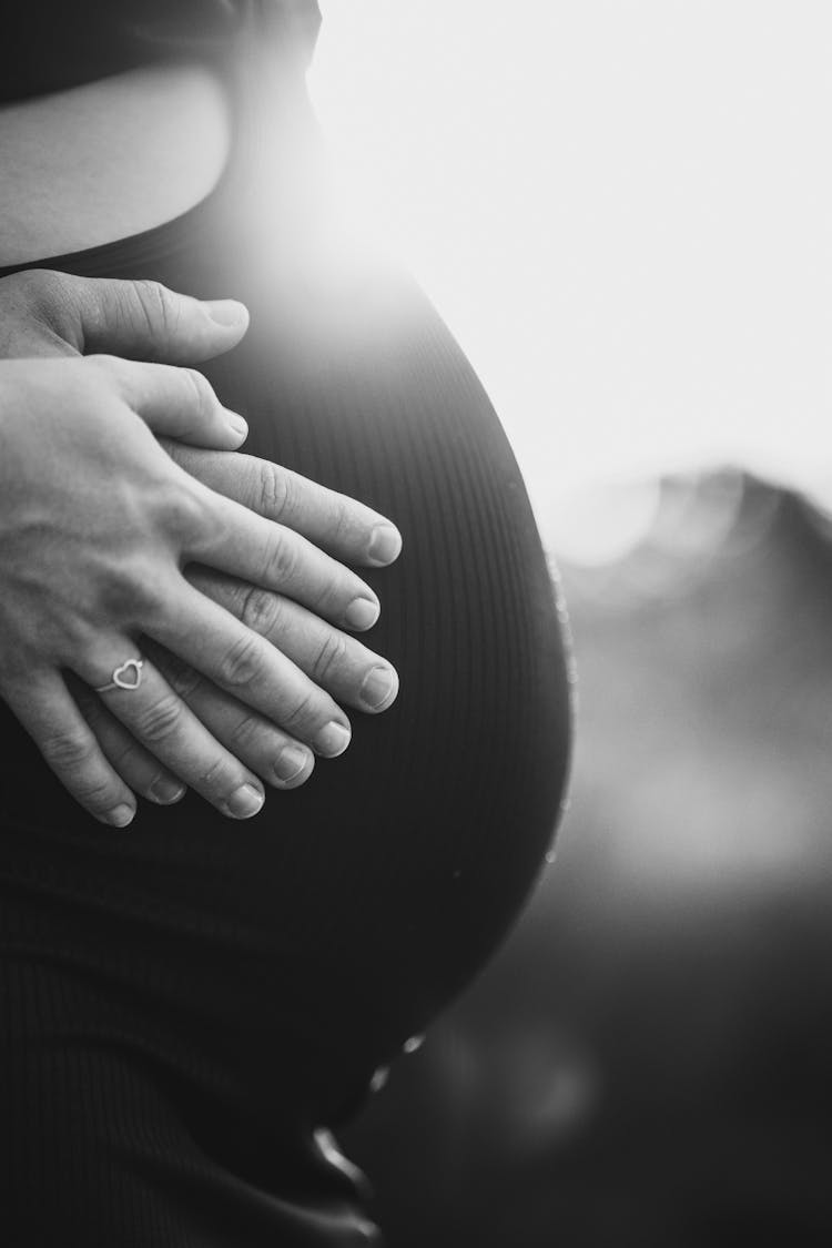 Couple Holding Hands On Pregnant Belly