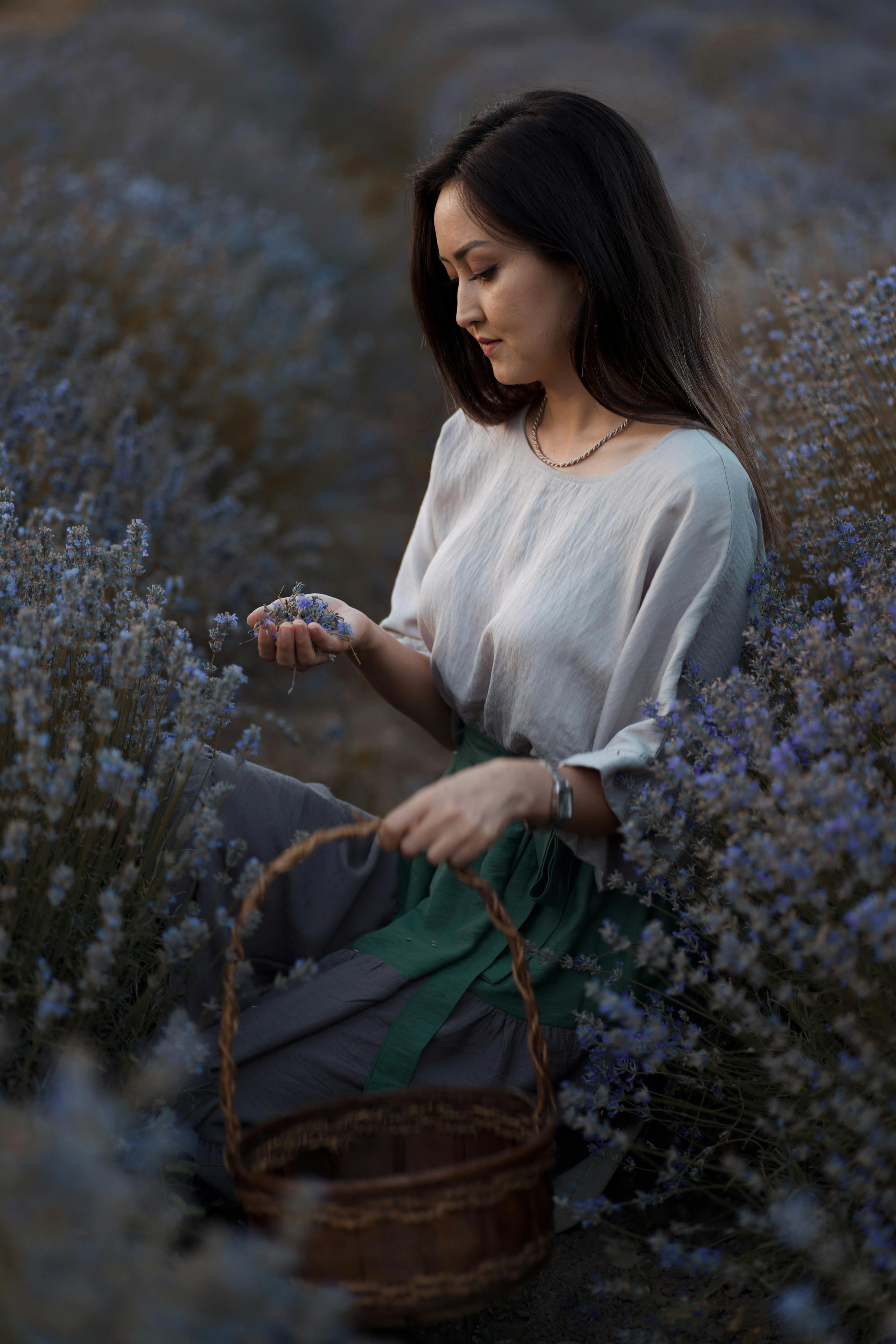 Young woman with black hair picking lavender in Safranbolu, capturing serene rural beauty.