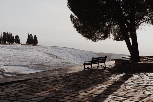 Free A tranquil winter view of Pamukkale with a park bench and tree shadows. Stock Photo