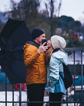 Couple sharing a kiss under an umbrella in rainy İstanbul street.