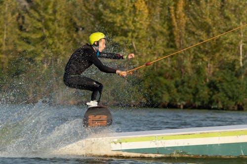 Man in Yellow Helmet Jumping on a Wake Board