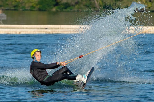 Man in Yellow Helmet Riding on a Wake Board