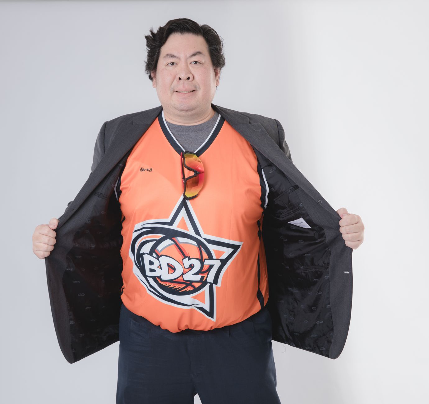 Portrait of a man showing a sports jersey with basketball graphic and BD27 logo.