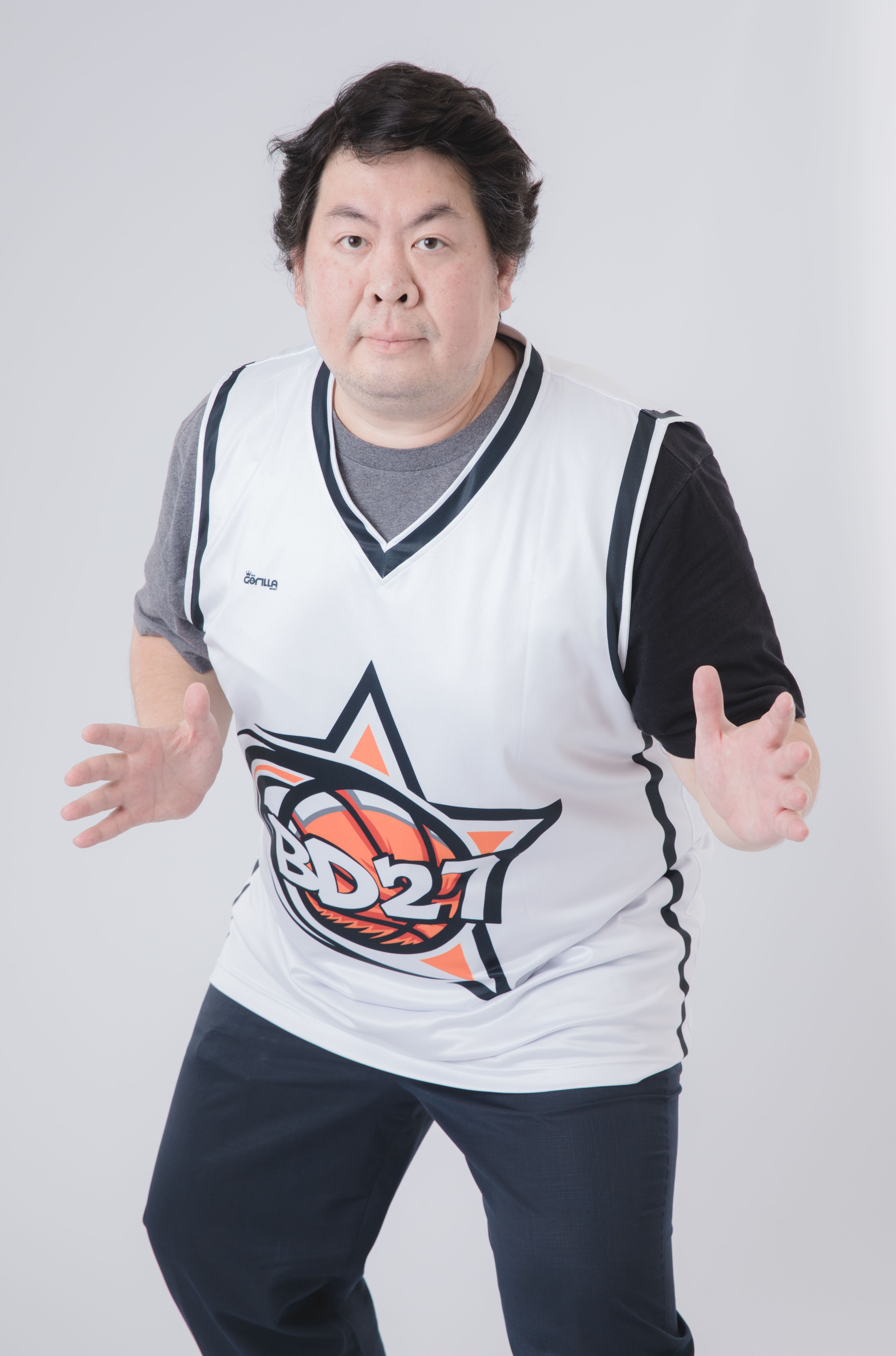 Asian man posing in a fashion studio shoot wearing a unique BD21 basketball jersey.