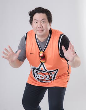 Adult man in sportswear posing for a basketball-themed photoshoot indoors.