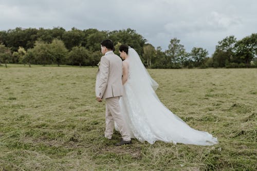 Elegant Groom and Bride Walking on Grass