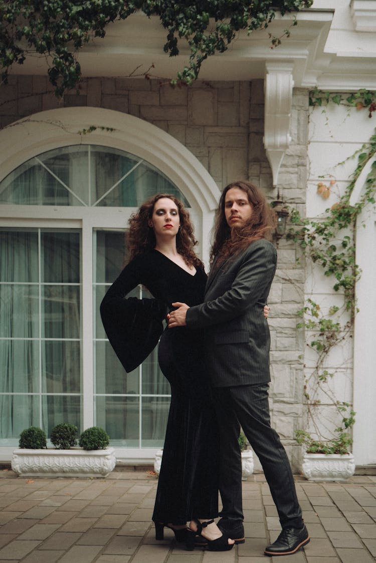 Couple In Black Posing In Dance Pose Against House