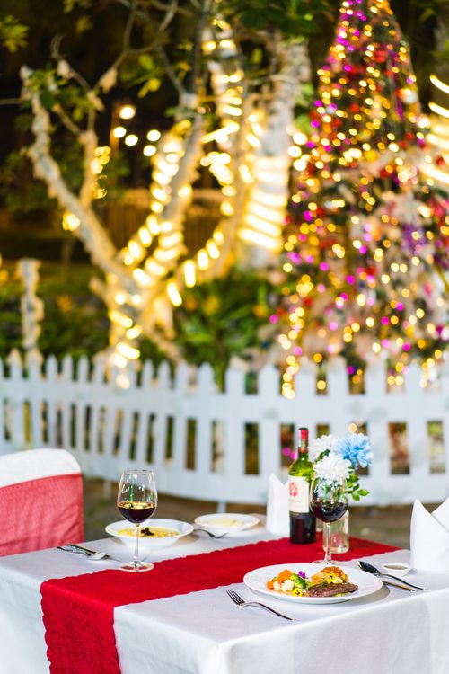 Free Intimate dining table set outdoors with wine and festive holiday decorations. Stock Photo