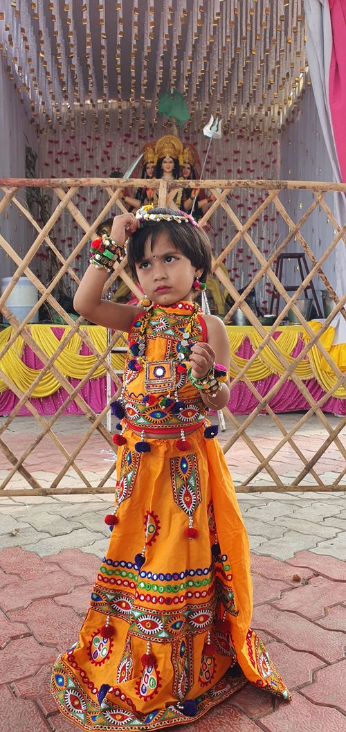 Free South Asian child in vibrant lehenga during a cultural festival celebration indoors. Stock Photo