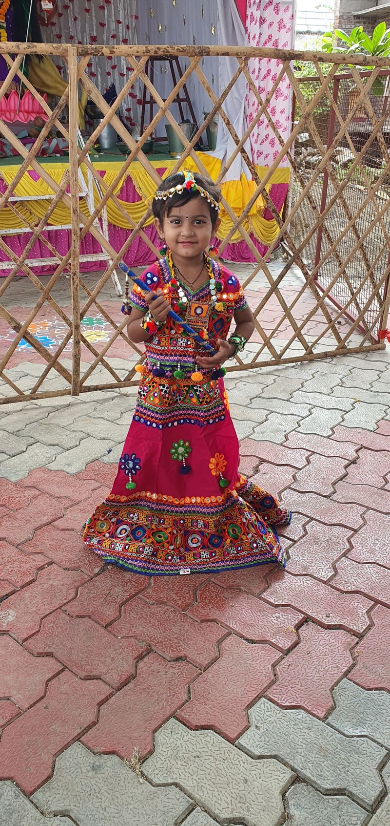 Guest in traditional red lehenga standing beside a Navratri altar