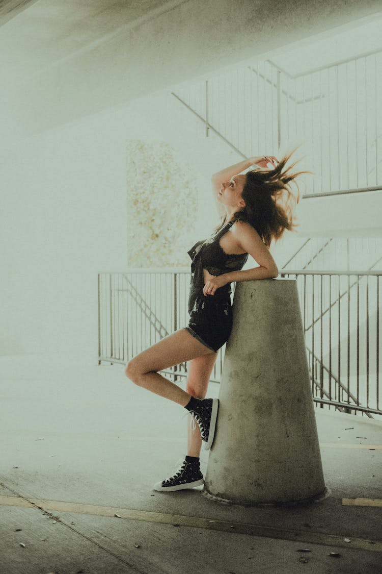 Woman Standing And Leaning On Post