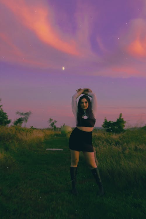 A Woman Posing in a Field at Dusk