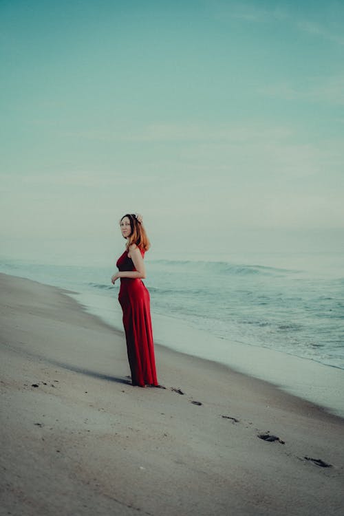 Woman in Red Dress on Sea Shore