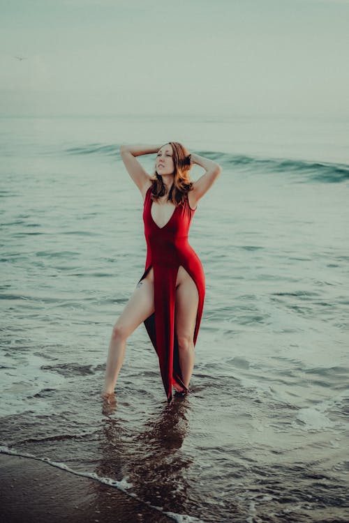 Woman in Red Dress Standing on Sea Shore