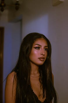 Captivating portrait of a brunette woman with striking makeup in an indoor setting.