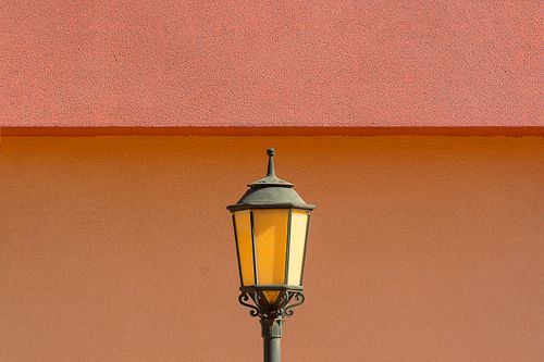Free Retro-style lantern set against a striking colorful wall, ideal for creative design projects. Stock Photo