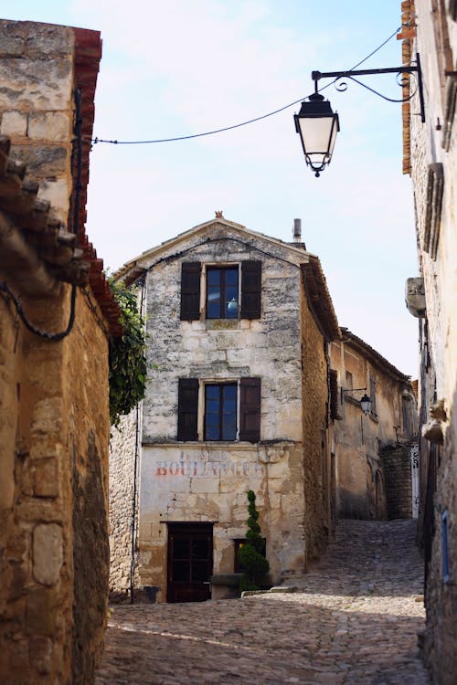 A narrow street with a stone building and a window