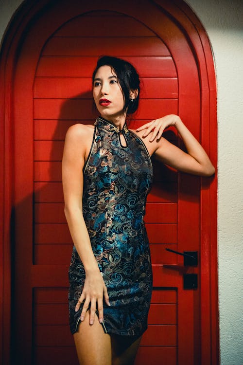 Model in Dress Standing by Red Door