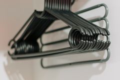 A stack of metal clothes hangers hanging in an empty closet wardrobe.