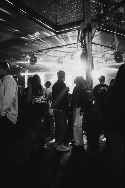 Dynamic black and white photo capturing a lively concert atmosphere with an engaging crowd in Concepción, Chile.