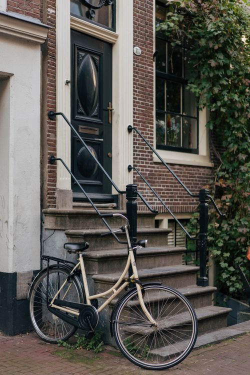 Free Charming Amsterdam street scene with a vintage bicycle against a traditional brick house. Stock Photo