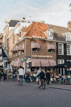 Street view of cyclists and pedestrians outside a popular Amsterdam cafe.