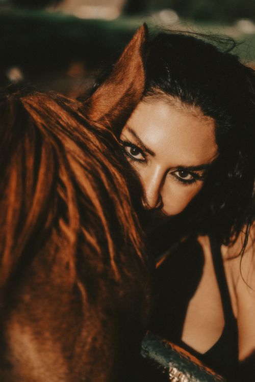 Free Intimate portrait of a woman with a horse, capturing deep connection and emotion. Stock Photo