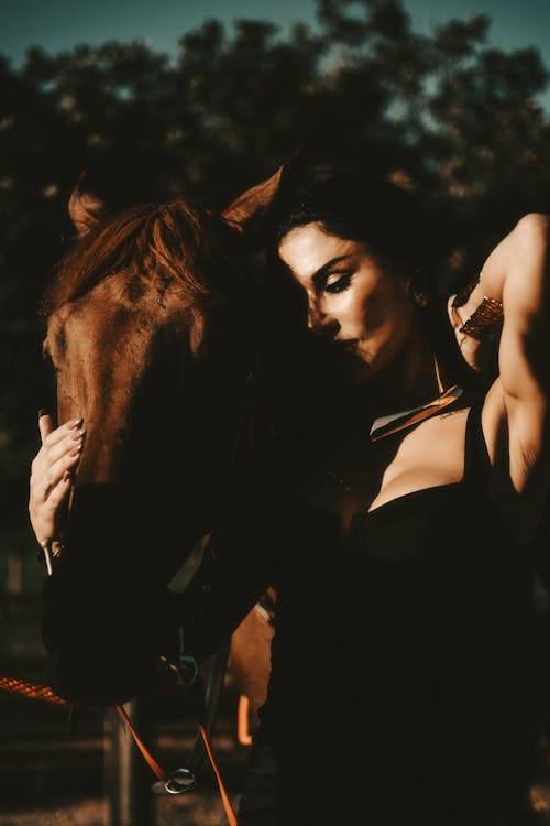 Beautiful Woman in Black Dress Posing with Horse