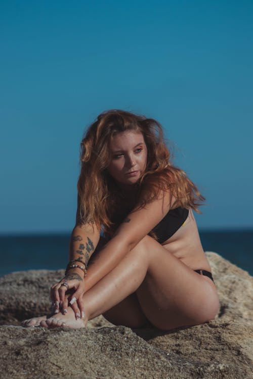 Woman in Swimsuit Posing on Rock