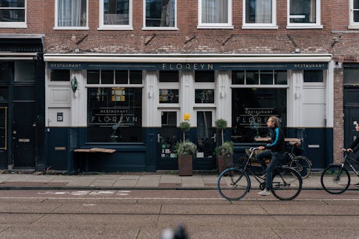 City street scene with cyclists and Floreyn restaurant facade in Amsterdam, Holland.