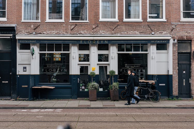 Pedestrians Walking Along Restaurant In City