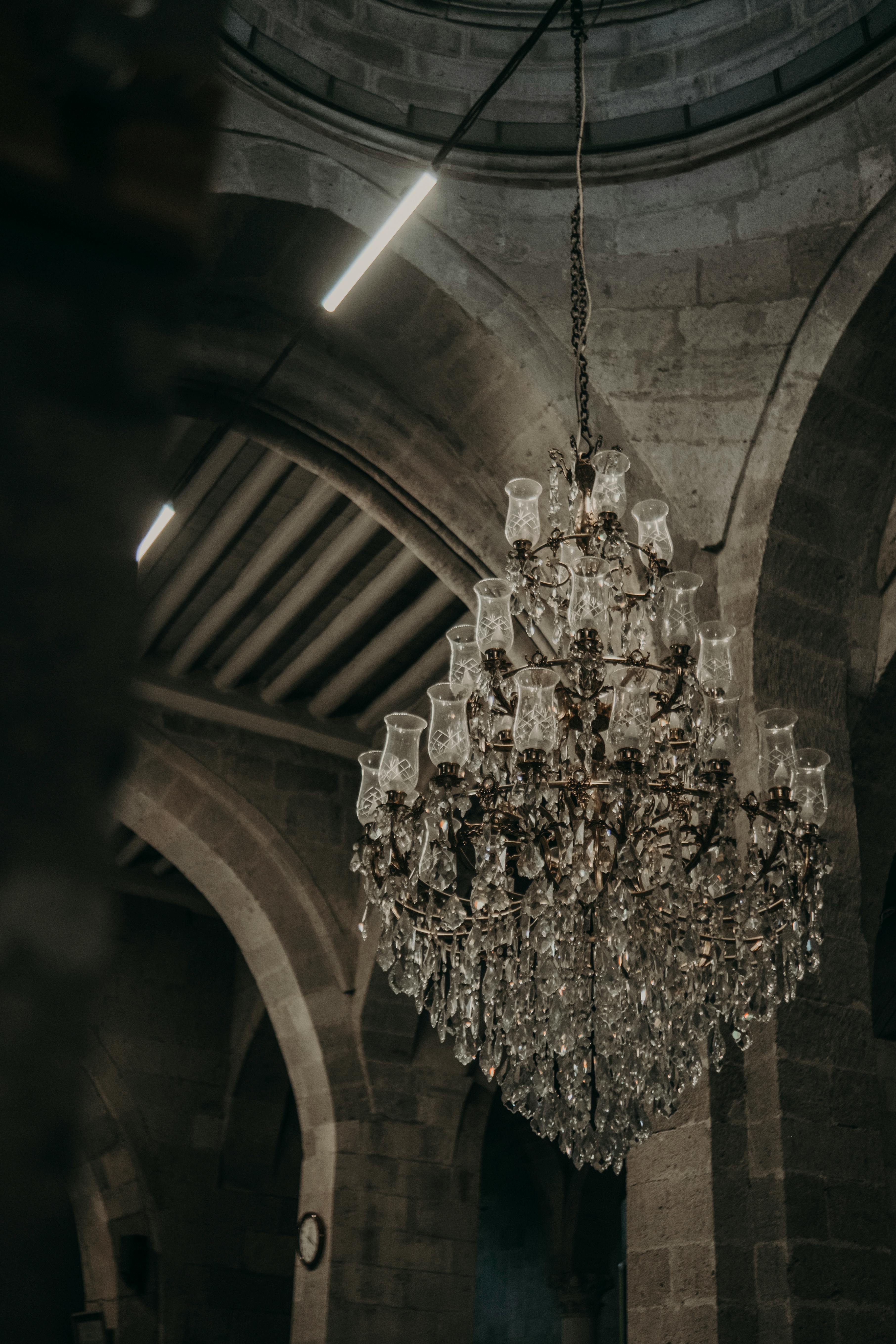 A detailed view of a classic crystal chandelier inside a historic stone church interior.