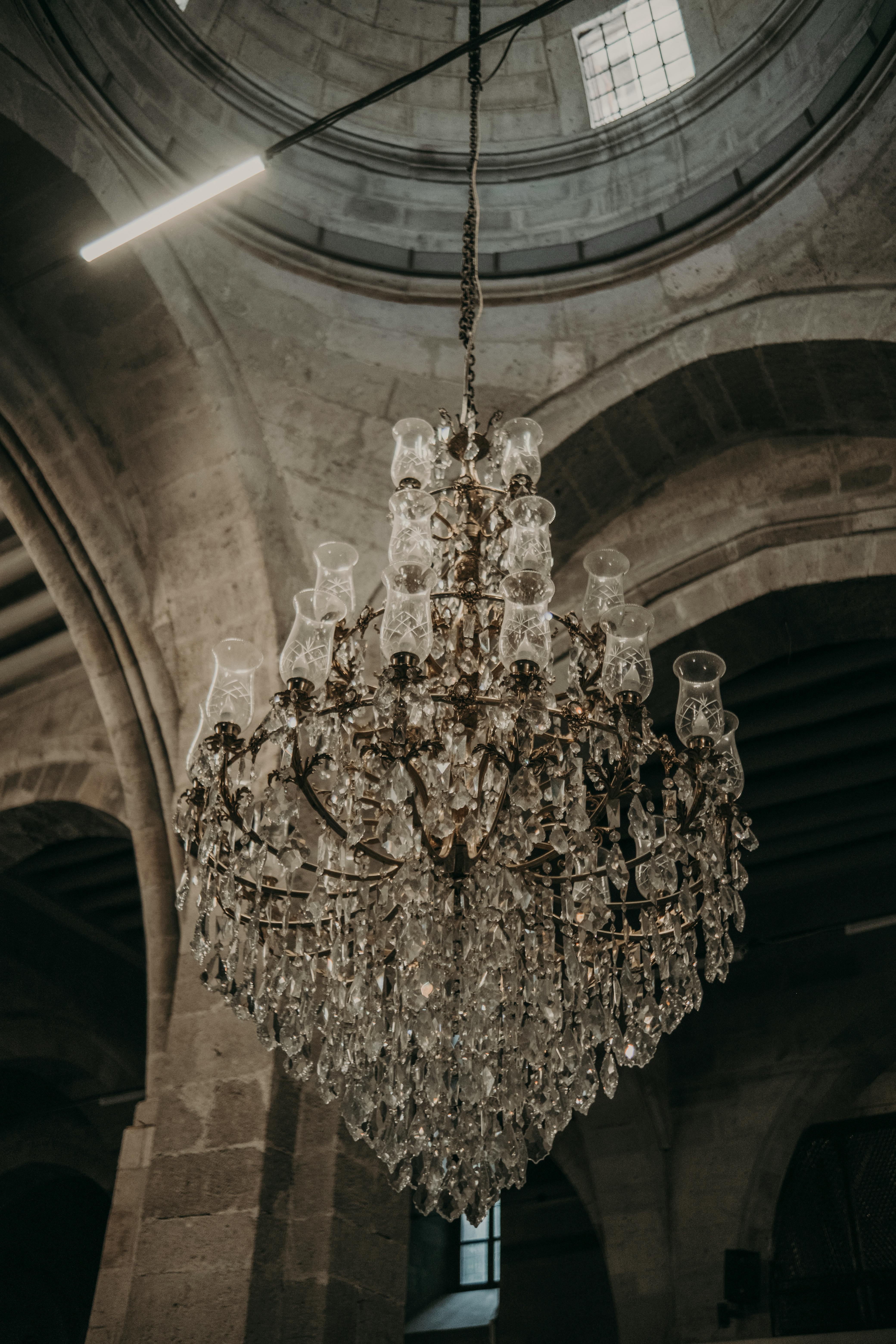 Intricate crystal chandelier in a mosque interior showcasing ornate architecture.