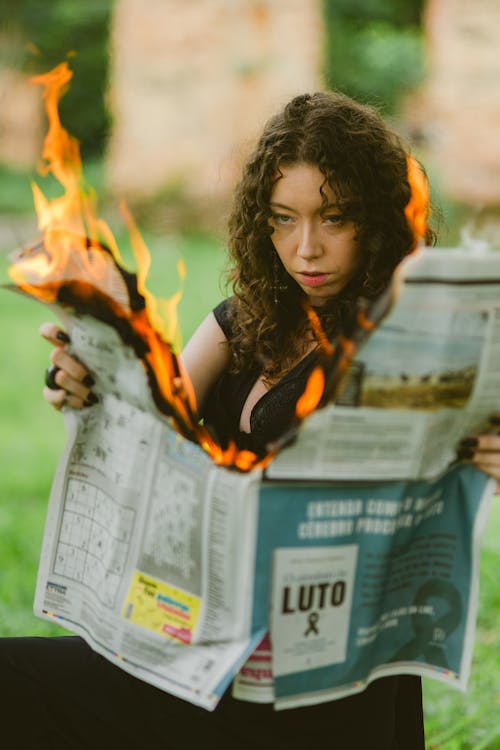 Woman Holding Burning Newspaper