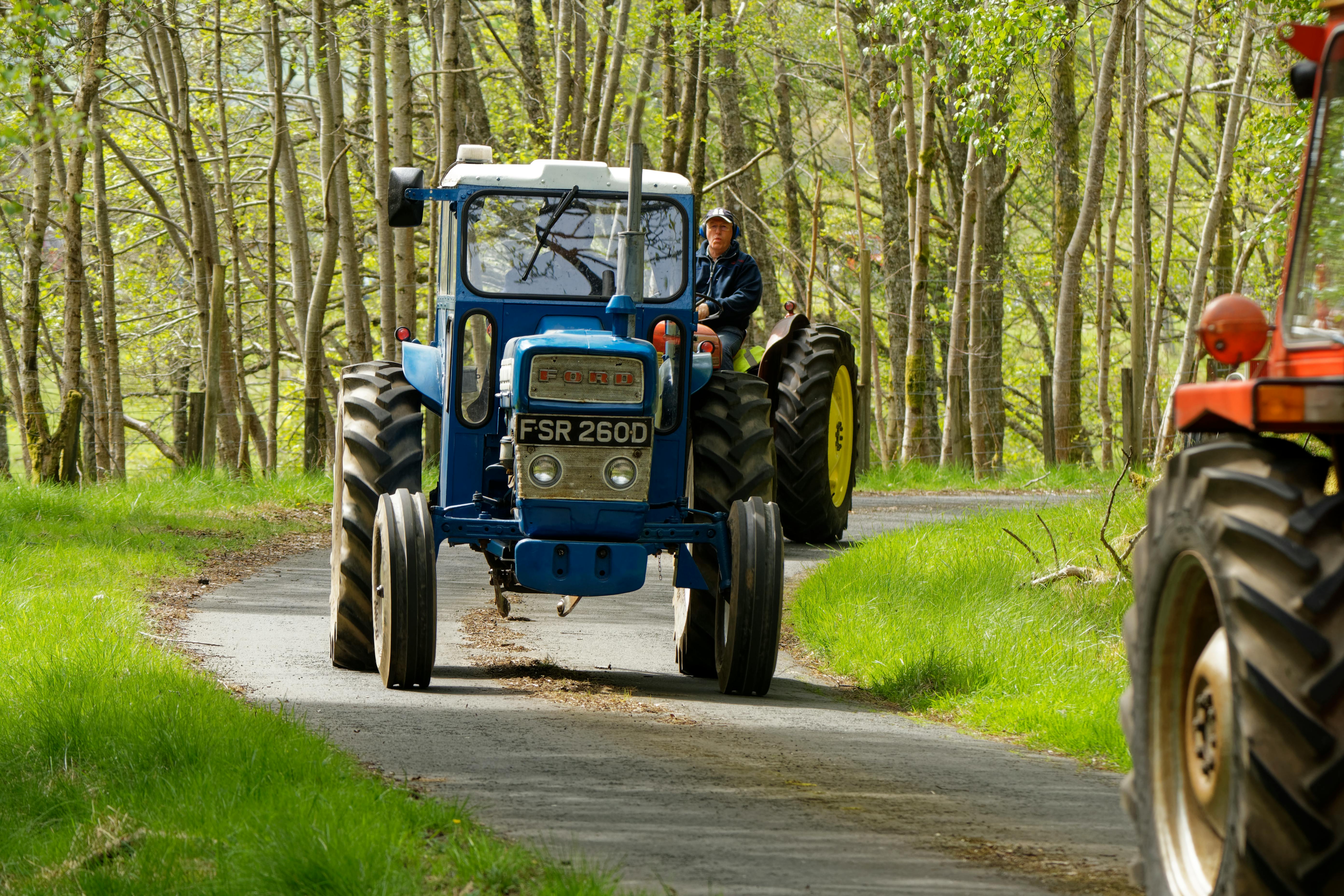 tractors on the road between trees