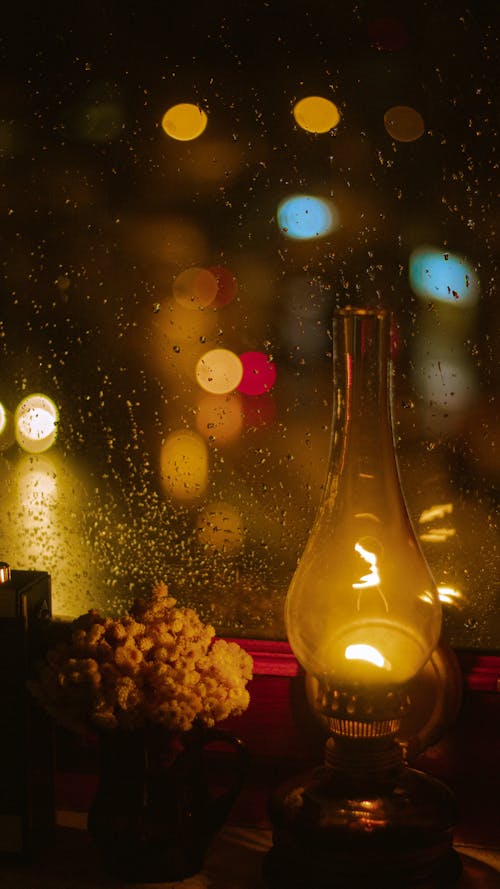 Raindrops on Window Glass behind Lamp at Night