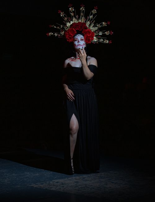 Free Woman in Halloween costume with floral headdress and face paint standing in dramatic lighting. Stock Photo