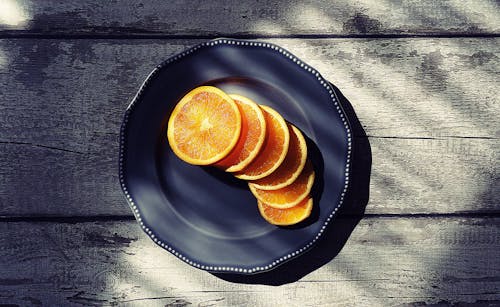 Sliced of Orange Fruits on Black Plate