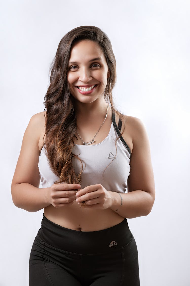 Smiling Young Woman In Sportswear Posing In Studio