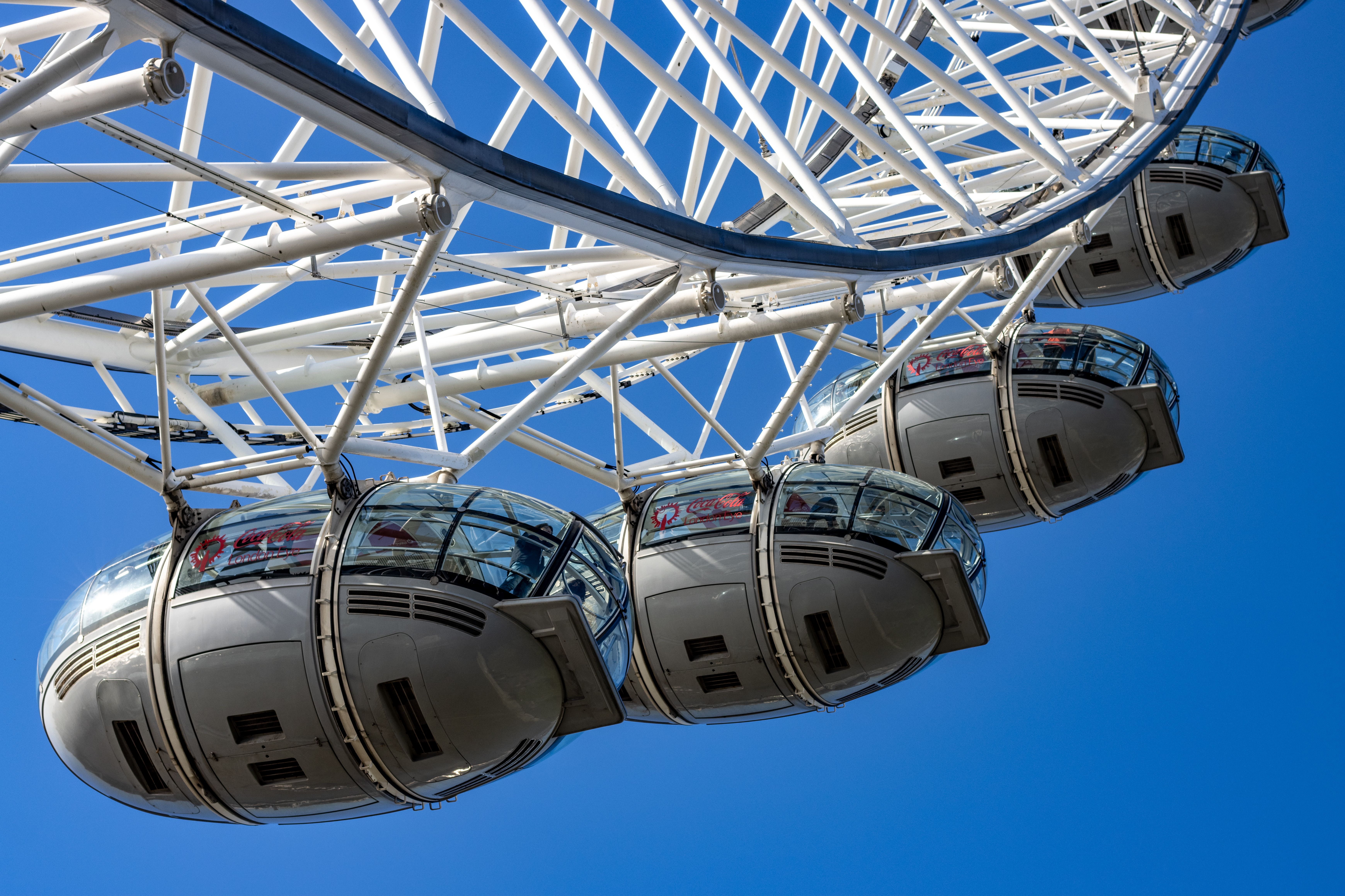 A detailed view of the London Eye capsules against a clear blue sky.
