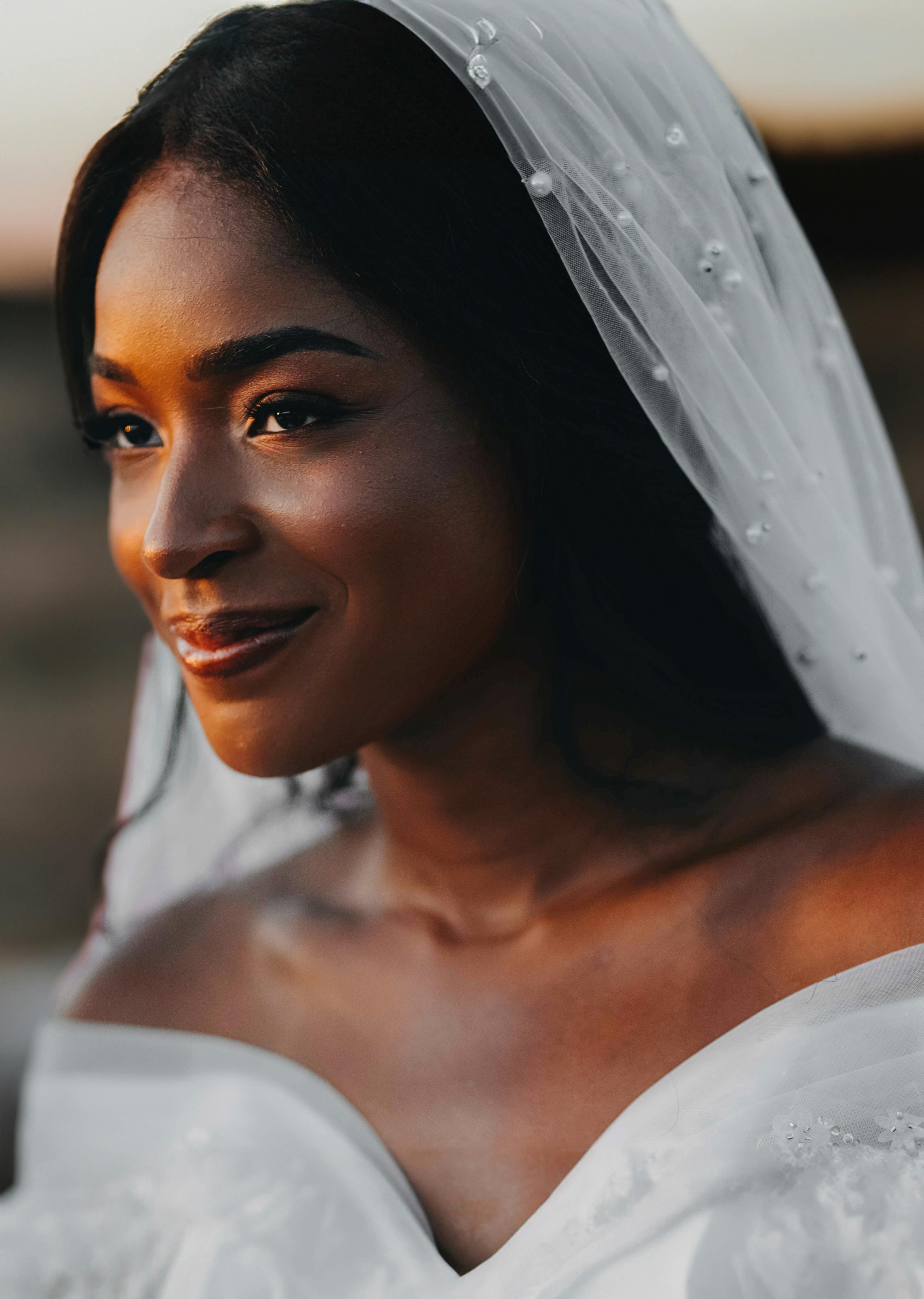 Beautiful black bride smiling with veil, captured during a sunset in Brazil.