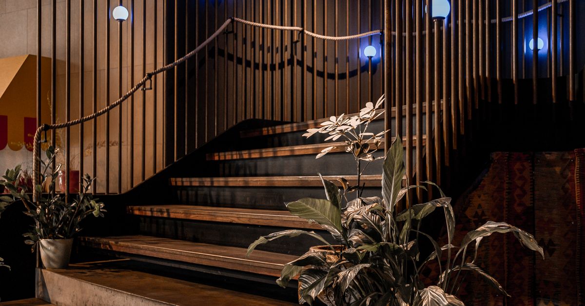 Stairs with Floor to Ceiling Railing Decorated by Blue Lamps in the ...