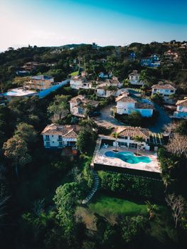 Stunning high angle view of luxury houses with swimming pools in Armação dos Búzios, Brazil.