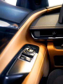 Detailed shot of a luxury car's leather interior and control panel, emphasizing elegance.
