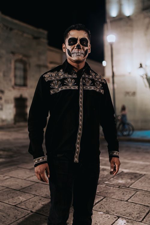 Free A man with skull face paint celebrates Day of the Dead in Oaxaca at night. Stock Photo